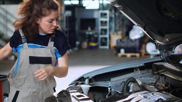 preciso mecânico dentro garagem usando torque chave inglesa para apertar parafusos dentro aberto acima veículo depois de mudando óleo. auto reparar fazer compras empregado fazendo checar em carro, limpeza sobras bagunça video