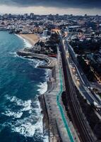 aéreo zumbido ver de marginal avenida y línea costera con mirando Oeste hacia Cascais en un nublado otoño día foto