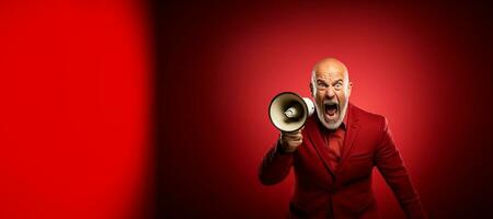 Senior man screaming into a loudspeaker isolated on red background. Generative AI photo