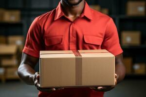 A delivery employee at a logistics warehouse holds a cardboard box.Generative AI photo