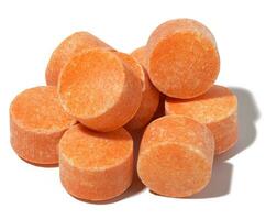 Round orange tablets on a white isolated background, vitamin C photo