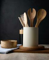 Empty bowl and wooden spoons on a table, black background photo