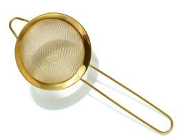 Golden strainer for bulk products on a white isolated background, top view photo