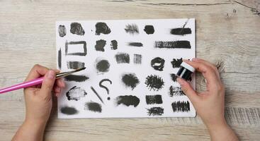 Various black strokes on a white sheet of whatman paper, top view photo