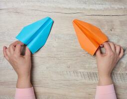 Female hands hold paper airplanes, representing the concept of mentorship and support photo