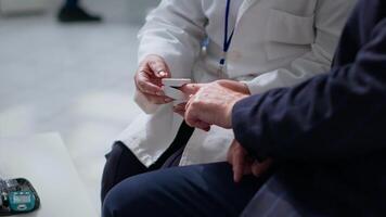 Close up of specialist clipping patient finger using pulse oximeter, monitoring level of blood oxygen saturation and heart rate during consultation in chemist store offering full range of services video