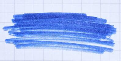 Hatching with a blue felt-tip pen on a sheet of checkered paper photo