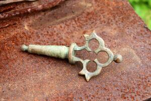 An old metal village handle from a samovar - a device for boiling water for tea. Part of the samovar - the tap handle - close-up, horizontal photo. photo