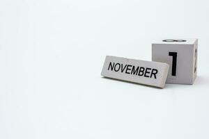 Wooden block calendar showing the date of November 1 on white background photo