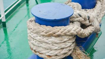 Mooring rope on soil, equipment on boat for parking in the port, naval rope white color on coil. photo