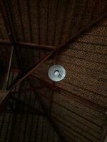 A lamp hanging from the roof of a wooden house shoot from below looks aesthetic photo