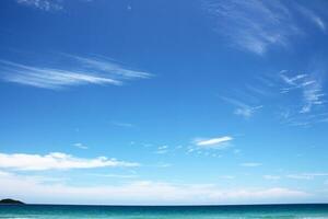 White clouds and blue sky on ocean sea textured background photo