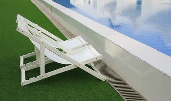 white beach deck canvas chair bed longue on the green grass photo