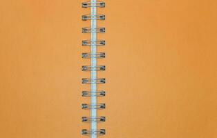 Blank orange notebook paper with ring spine for background photo