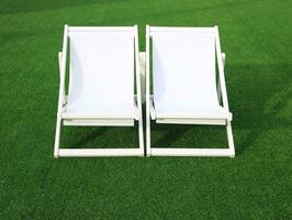 white beach deck canvas chair on the green grass photo