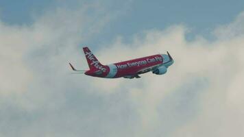 PHUKET, THAILAND NOVEMBER 26, 2016 - Airbus A320 of AirAsia taking off and climbing at Phuket Airport, side view. Footage plane departure. Airplane rising in cloudy sky. Tourism and travel concept video