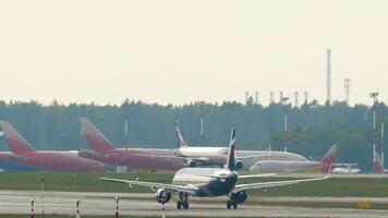 MOSCOW, RUSSIAN FEDERATION JULY 30, 2021 - Shot, Aeroflot passenger plane taking off at Sheremetyevo airport, rear view. Row of airplanes in the parking lot, background video