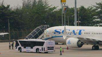 phuket, Thailand februari 25, 2023 - boeing 737 max. hoogte van scat luchtvaartmaatschappijen Aan schort Bij phuket luchthaven. bord aankomst. trap aanmeren met de vliegtuigen. schort bus aan het wachten voor passagiers video