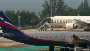 Phuket, Tailandia febbraio 25, 2023 - passeggeri aereo airbus a330, ra73789 di aeroflotta rullaggio a Phuket aeroporto terminale. Emirates corpo largo, sfondo video