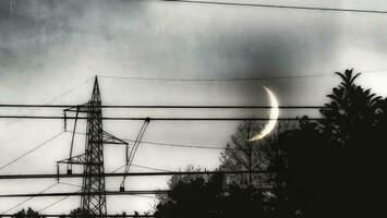 dark horror halloween photo of the moon among many electricity poles