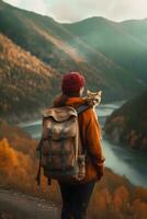 young woman in hat with big backpack hiking with ginger cat in mountains in fall Tourism and travel with pets concept photo