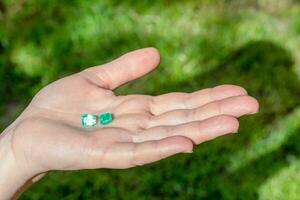 Natural emerald stone in hand photo