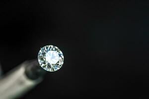 Diamond in jeweler tweezers photo