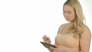 Studio shot of pregnant caucasian woman holding tablet video