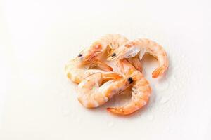 Raw thawed prawns with water drops on a pink background. Mediterranean food photo