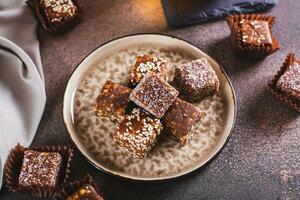 Sugar free candies made from fruit paste, nuts and sesame seeds on a plate photo