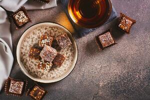Healthy candies made from figs, dates, nuts, coconut and sesame seeds on a plate top view photo