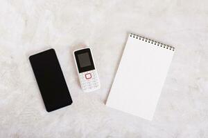 Alternative between modern smartphone, feature phone and notepad top view photo