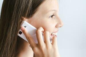 Girl holding an old-fashioned push-button telephone with her hand to her ear photo