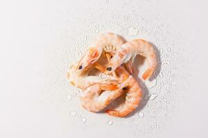 Raw thawed prawns with water drops on a pink background. Mediterranean food. Hard light. Top view photo