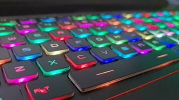 A gaming keyboard that has colorful LED lights, with the main color of the keyboard being black. It has a shape that is very suitable for the hand when typing or playing games. video