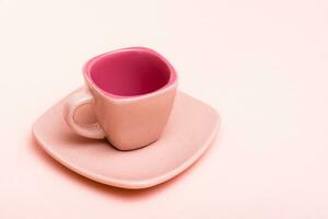 Pink concept. Empty square coffee cup on a saucer on a pink background photo