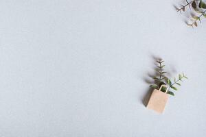 Green Friday paper craft bag with branches on a green background top view copy space photo