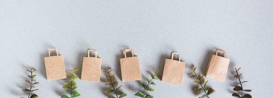 Green friday paper craft bags and twigs on green background top view web banner photo