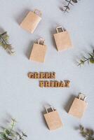 Green Friday inscription and paper craft bags on a green background top and vertical view photo