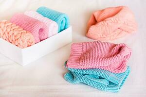 Organization and order. Knitted clothes are in disarray next to a box of neatly folded items photo