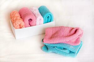 Organization and order. Knitted clothes lie next to a box of neatly folded things. photo