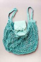 Eco-friendly gift - box wrapped in cloth in a mesh bag on a gray background. Minimalism. Blue palette photo