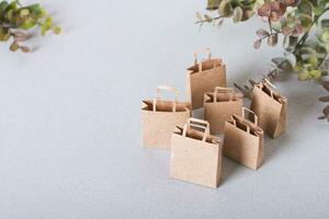 Green Friday paper craft shopping bags and leaves on the table view above photo