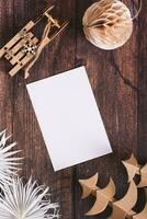 Blank sheet for gift list in homemade Christmas decorations on table top and vertical view photo