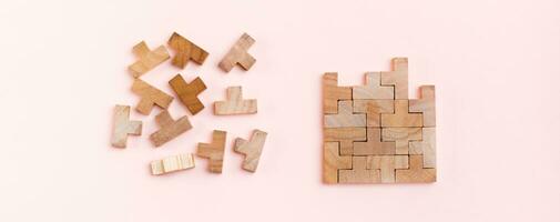 Organization and order. Wooden puzzle pieces are stacked correctly and chaotically scattered in disarray on a pink background. Web banner photo