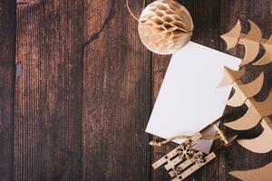 Wish list for santa claus, sleigh, cardboard tree and homemade ball on the table top view photo