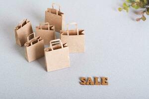 Green friday sale paper craft shopping bags and leaves on table photo