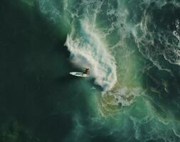 Surfer at the top of the wave in the ocean, top view photo