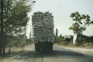 un foto de un sobrecargado camión en la carretera en jepara