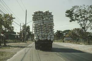 un foto de un sobrecargado camión en la carretera en jepara